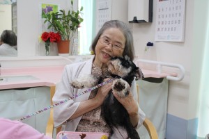 笑顔でドッグセラピー活動をうけるお年寄り